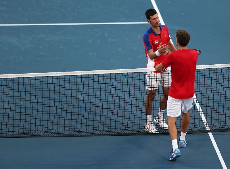 Novaks Džokovičs un Pablo Karreno Busta apskaujas pie tīkla